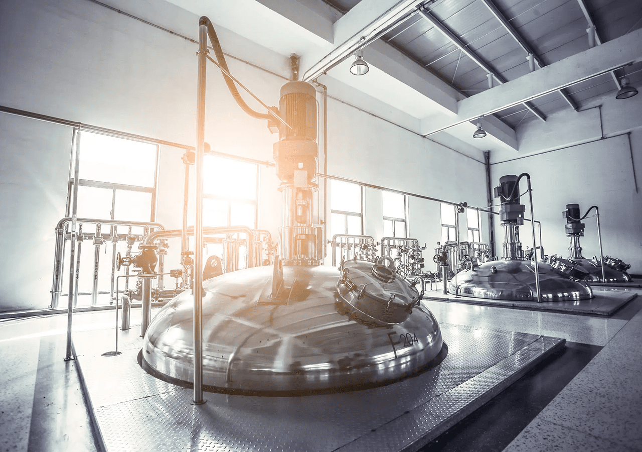 Industrial stainless steel tank in a bright factory setting.