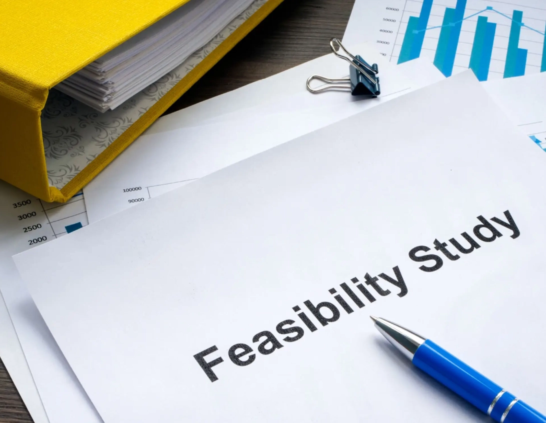Close-up of a feasibility study document with a pen and binder clip.