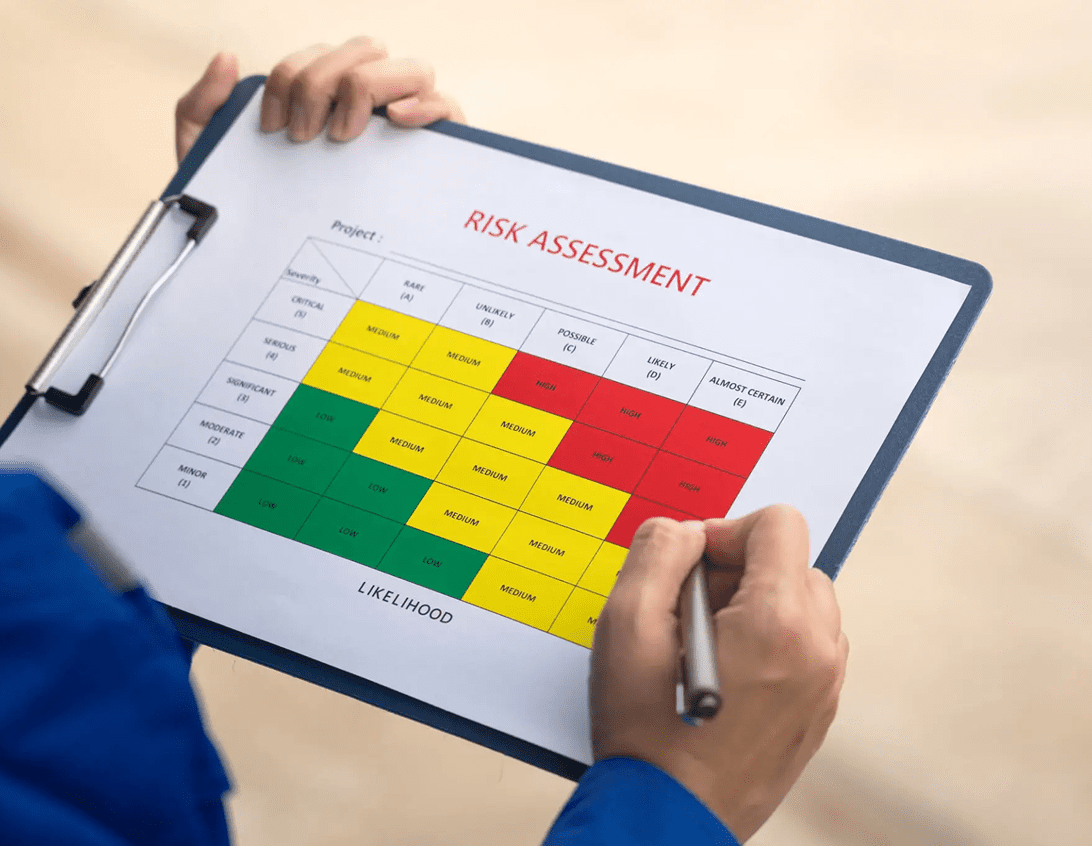 Person holding a risk assessment chart with color-coded risk levels.