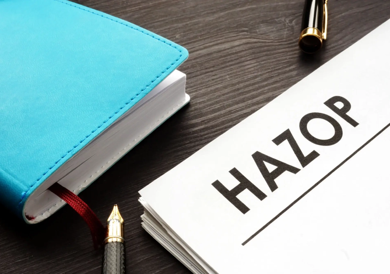 A notebook, a pen, and a card labeled 'HAZON' on a wooden surface.